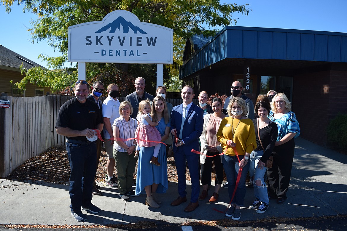 Dentist Calvin Despain, along with his wife, Brooke, and daughter, Elsie, surrounded by employees and members of the Moses Lake Chamber of Commerce, cuts the ribbon Friday on his new dental clinic at 1336 E. Hunter Place, Moses Lake.