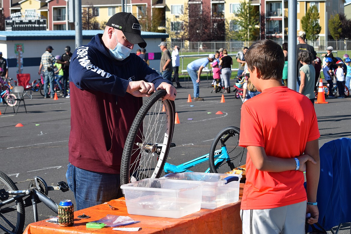 Volunteer Thomas Leighty shows a boy how to remove an inner tube and check it for leaks at the Moses Lake Kiwanis Club’s annual Bike Rodeo on Saturday at the Paul Lauzier Athletic Complex.