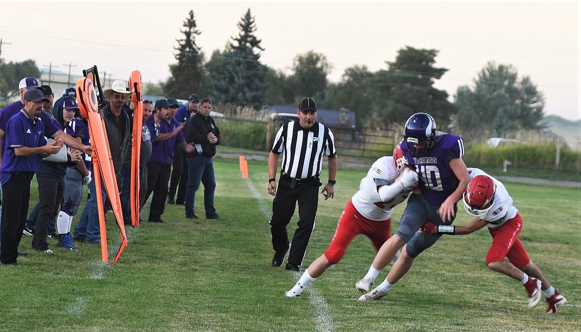 Charlo's Wes Anderson (40) tries to break through Arlee defenders Coyle Nagy (11) and Tayre Brown (23) along the sideline. (Scot Heisel/Lake County Leader)