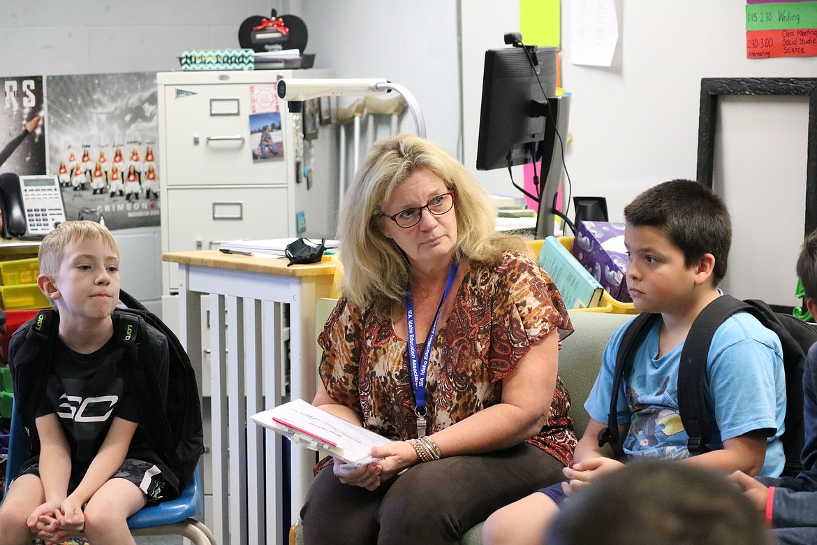 From left, Madden Taylor, fifth grade teacher Emmy Bonds and Colton Noel sit in a class discussion over the days events before announcements are given and class is dismissed at Prairie View Elementary School. HANNAH NEFF/Press