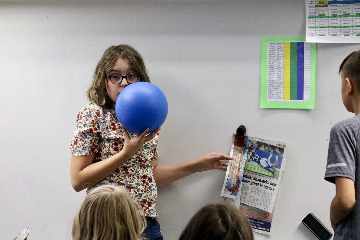 Fifth grader Lily Dawson speaks into the "talking ball" at Prairie View Elementary School to share with the class what she found interesting in The Coeur d'Alene Press on Sept. 16, an advertisement for Silverwood Theme Park with the end of season date. HANNAH NEFF/Press