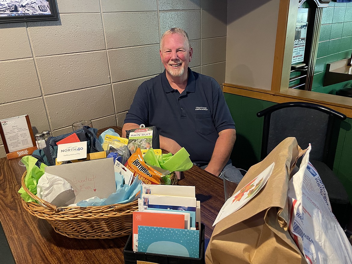 Recently retired Carl Larson, head custodian for Coeur d’Alene Charter Academy, sits among a basket of cards from student, staff, parents and alumni, as well as other gifts at his retirement party at Paddy’s Sports Bar on Friday. Larsen worked at the academy since it opened in 1999. Photo courtesy of Laura Beyer
