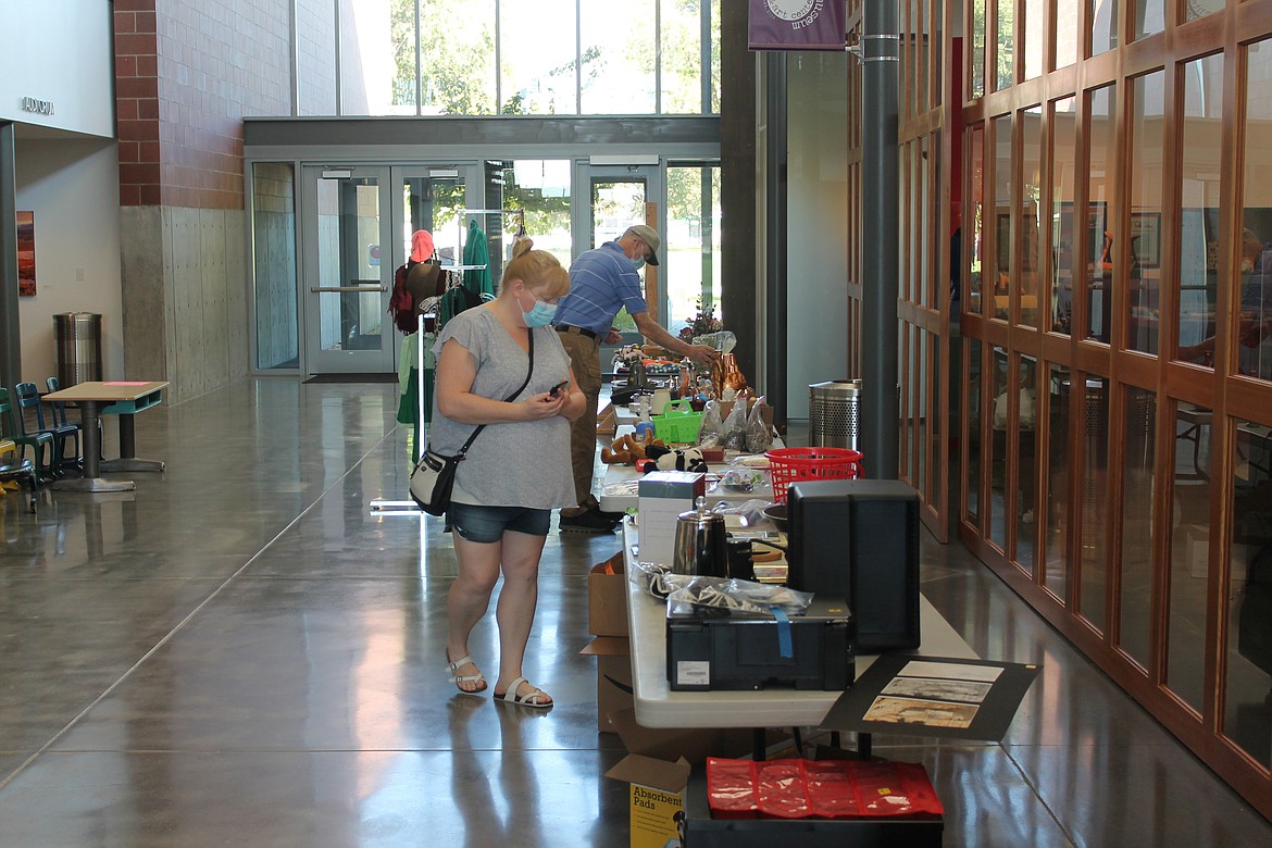 Crystal Norman, front, and Pat Fitzgerald, both of Moses Lake, browse through the offerings at the Moses Lake Museum & Art Center’s Rusty Mammoth sale Saturday. The sale raised $1,764 for the museum’s Family and Education Fund, according to museum director Dollie Boyd.