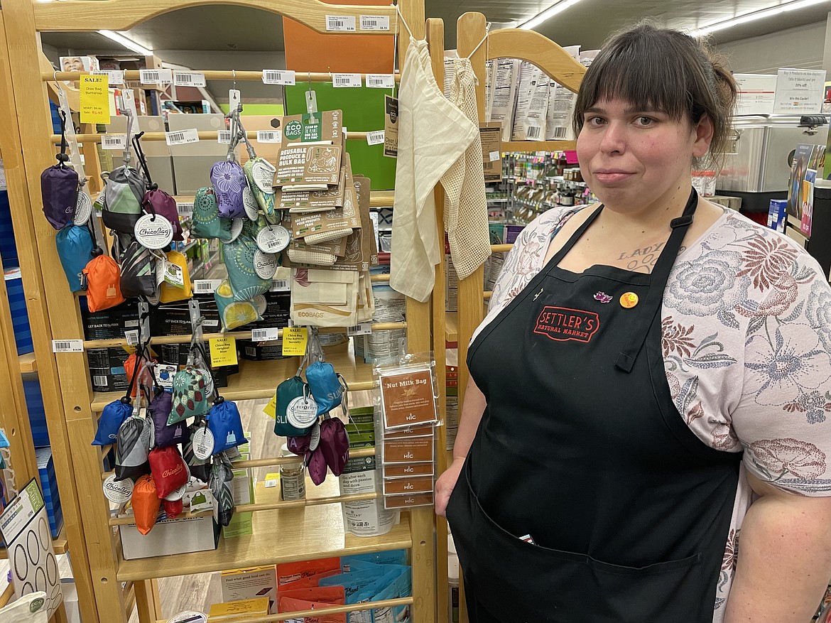 Alicia West, store manager of Settler’s Natural Market in Moses Lake, has a display of reusable plastic bags the store sells. The state’s ban on the sale of single-use plastic bags goes into effect on Friday.