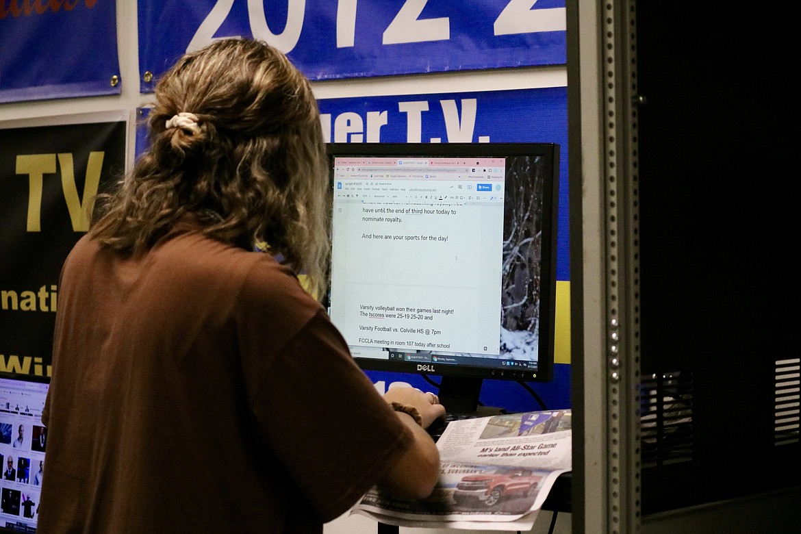 Sami Wilfong, a senior at Timberlake High school who is finishing up her third year in the video production class, uses The Coeur d'Alene Press to put the school's sports scores into the class broadcast script. HANNAH NEFF/Press