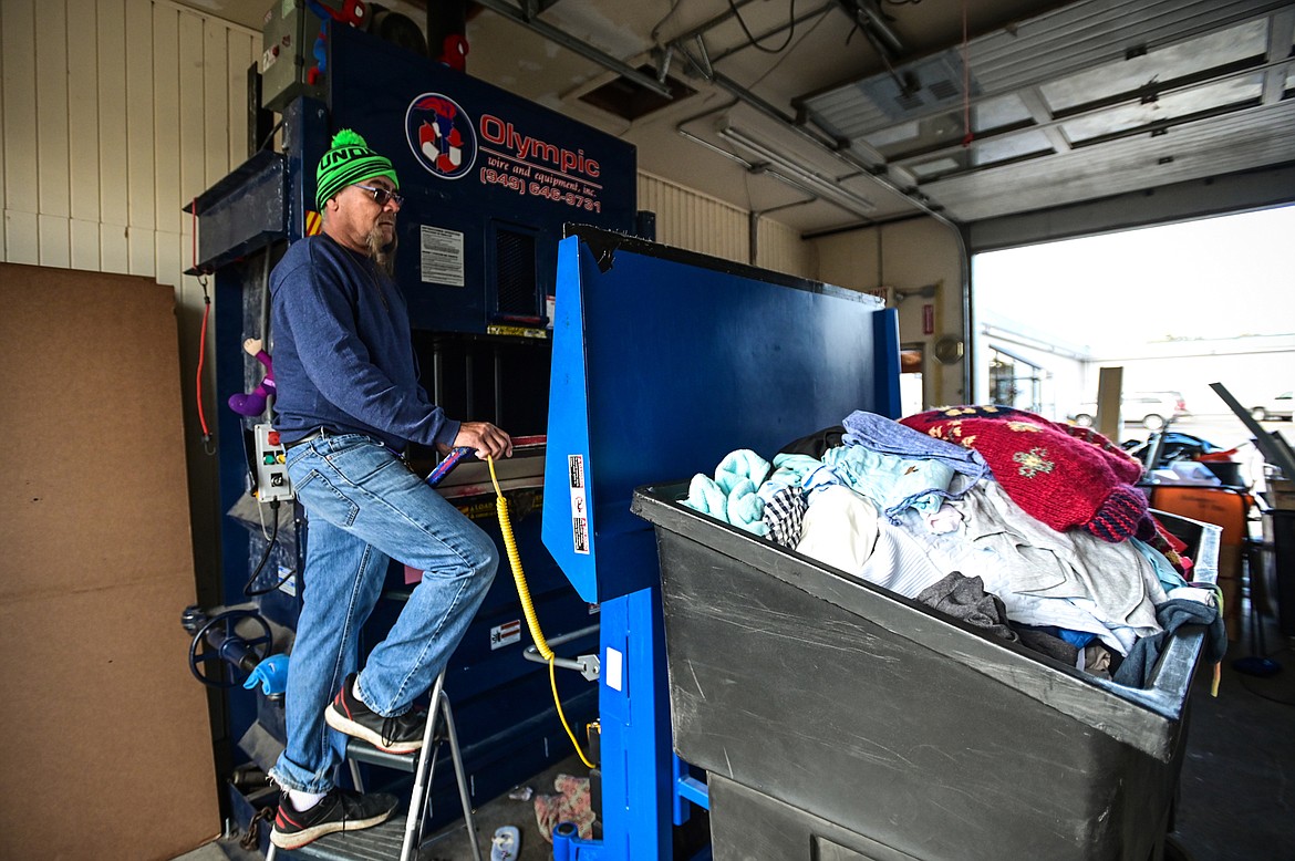 Michael Lopez loads a bin of unusable donations into a baler for compacting and recycling at Flathead Industries in Kalispell on Wednesday, Sept. 29. (Casey Kreider/Daily Inter Lake)