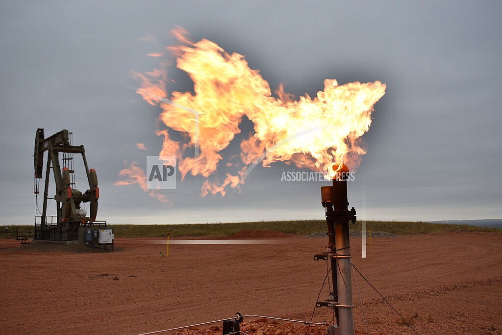 In this Aug. 26, 2021 file photo, a flare burns natural gas at an oil well Aug. 26, 2021, in Watford City, N.D. Consumers of natural gas are facing the prospect of much higher heating bills this winter. That's after enjoying a prolonged period of low prices. (AP Photo/Matthew Brown)