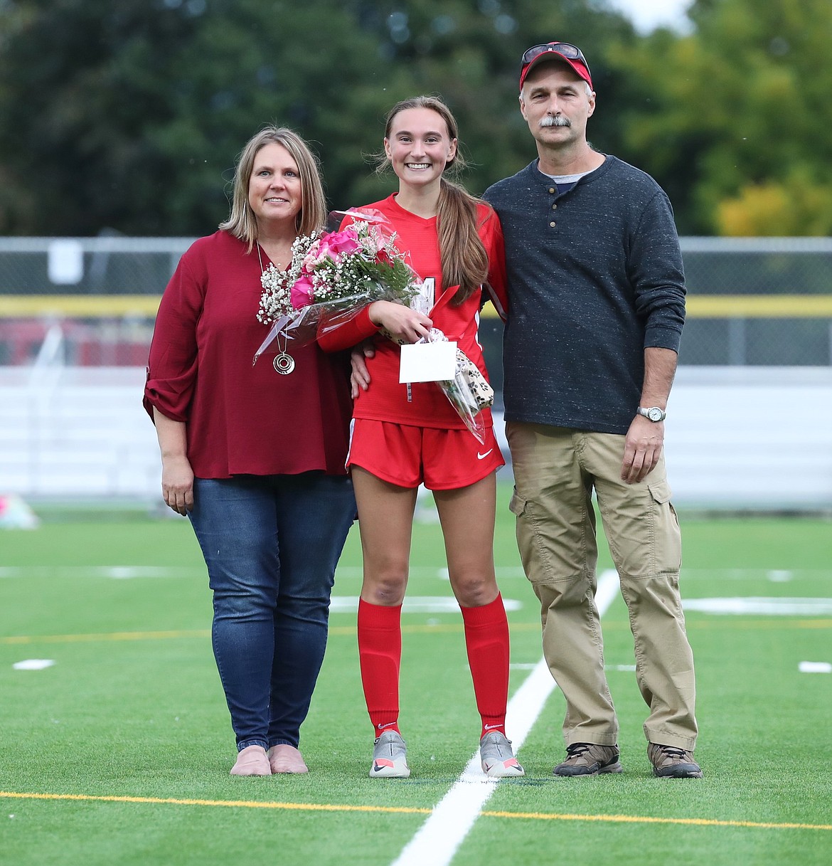 Kate McGregor poses for a photo with her family on Senior Night.