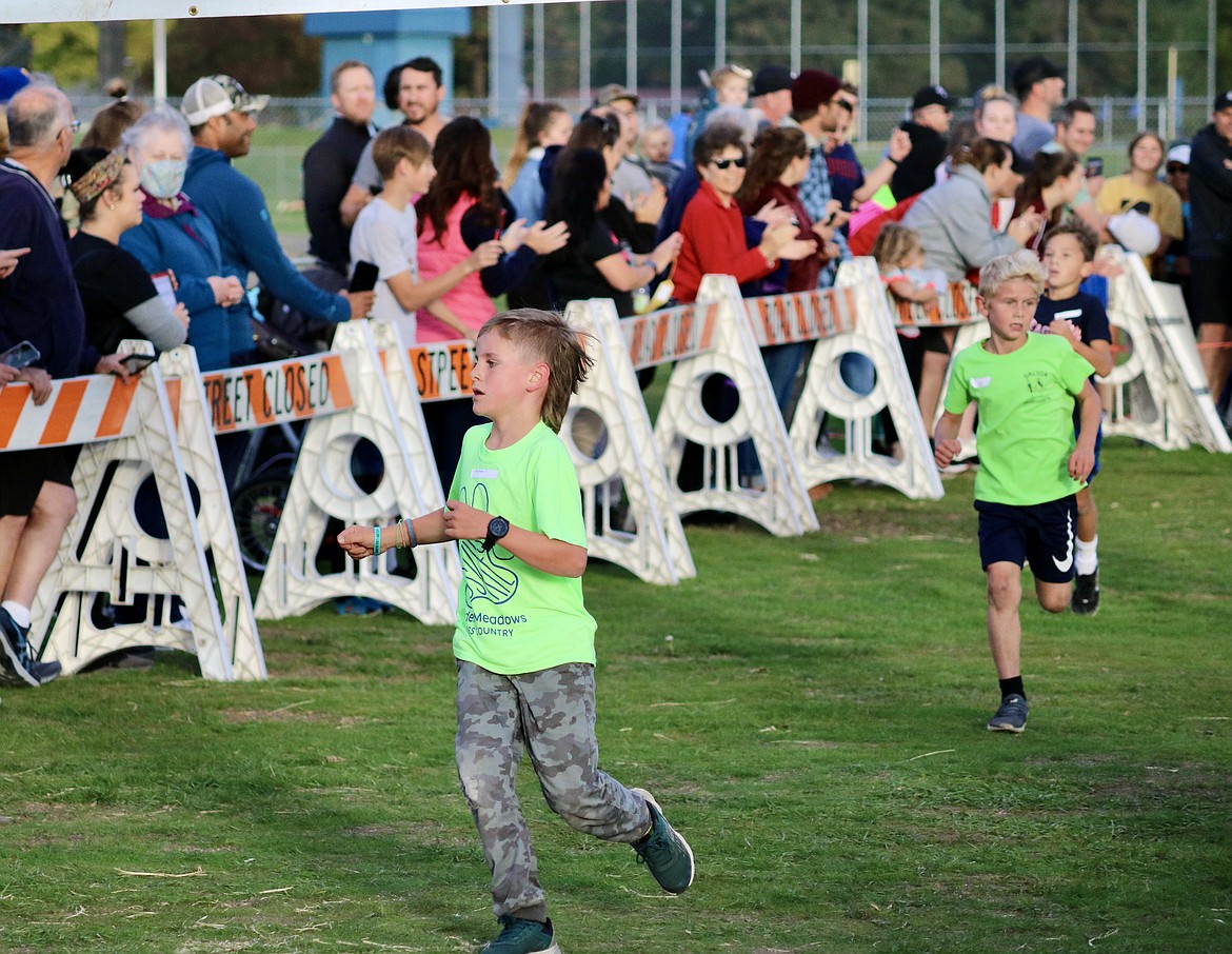 In front, Wyatt Beasley, a third grader from Hayden Meadows Elementary School, crosses the finish line to get first place for the third grade boys division at the Coeur d'Alene School District cross-country race at the Kootenai County Fairgrounds. HANNAH NEFF/Press