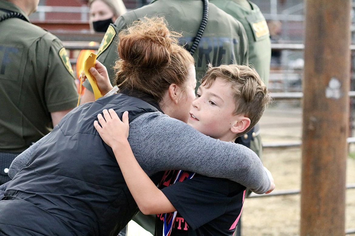 Second grade boys winner Easton Moore hugs his mom Kristin Moore at the Coeur d'Alene School District cross-country race on Thursday evening at the Kootenai County Fairgrounds. HANNAH NEFF/Press