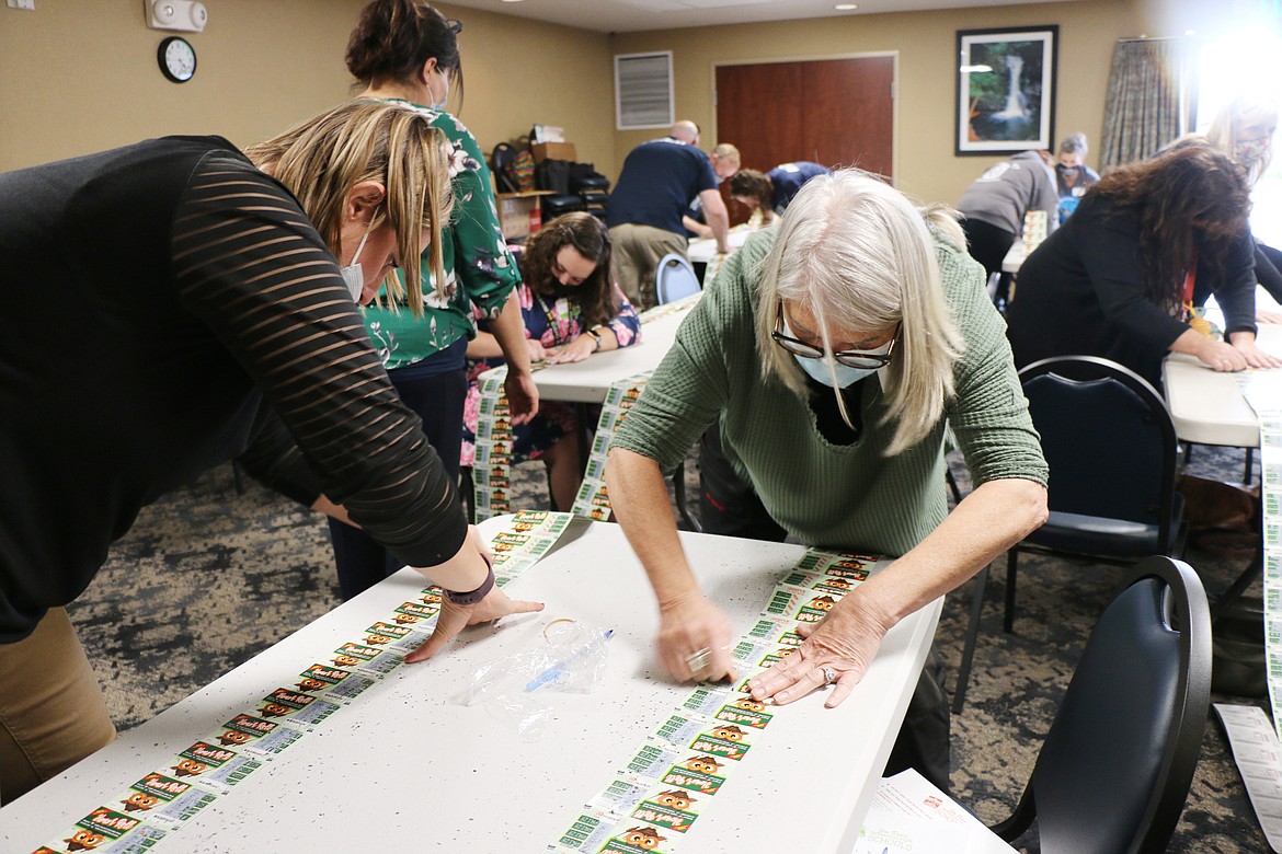 Bonner County teachers work to scratch as many lottery tickets as they can during the annual Scratch for Schools event held by the Idaho Lottery on Thursday in Ponderay. Teachers, staff and school officials have five minutes to scratch as many tickets as they can to win money for their schools.