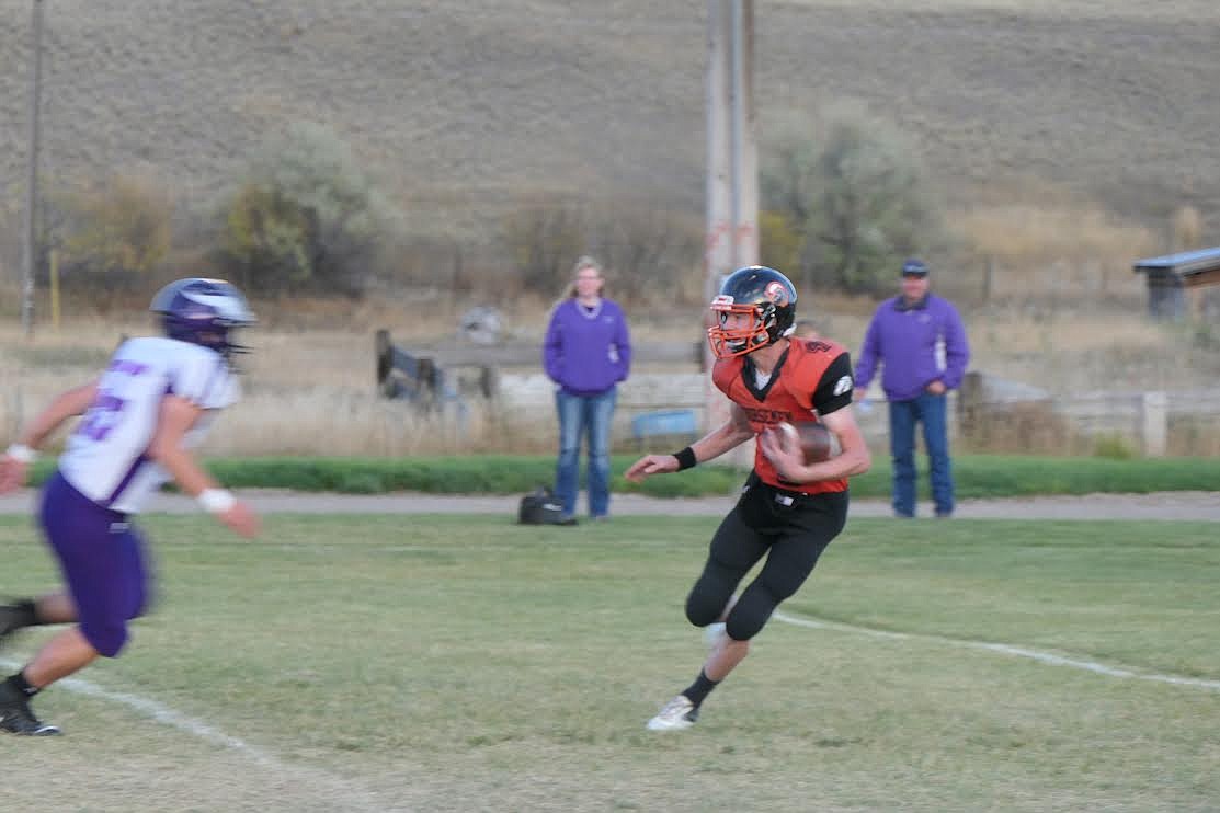 Plains football player Mason Elliott tries to evade a Charlo tackler during Saturday's game. (Adam Lindsay/Valley Press)