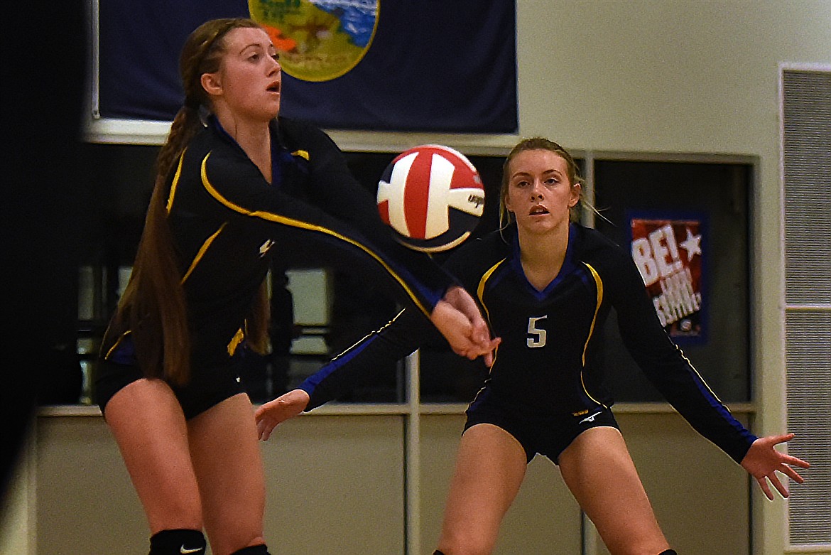 Thompson Falls McKenzie Robins receives a serve as teammate Natalie Roberts watches during the first set of the match last Saturday in Bigfork. The Lady Hawks won in five sets. (Jeremy Weber/Valley Press)