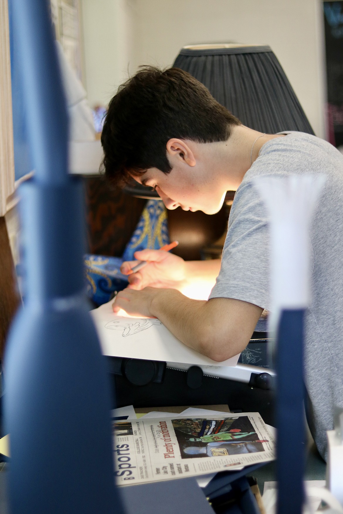 Liam McNamara, a tenth grader at Lake City High School, works on an art project for class. The week prior they used newspapers for a lesson on ethics in art, changing the photos at least 50% to make it their own. HANNAH NEFF/Press