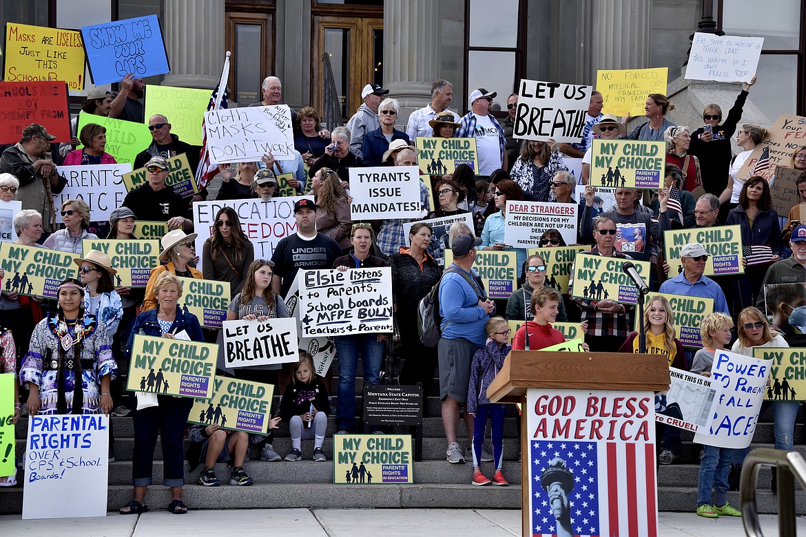 In this Friday, Oct. 1, 2021 file photo people gather to protest mask requirements in schools in front of the state capitol in Helena, Mont. A district judge in Missoula has denied a request by several parents to halt mask mandates in Missoula schools while a legal challenge of the mandates is underway. The parents sued several Missoula schools in August over their mask requirements, arguing they violated the state's constitution, which guarantees individuals the right to make their own medical decisions. (AP Photo/Iris Samuels,File)