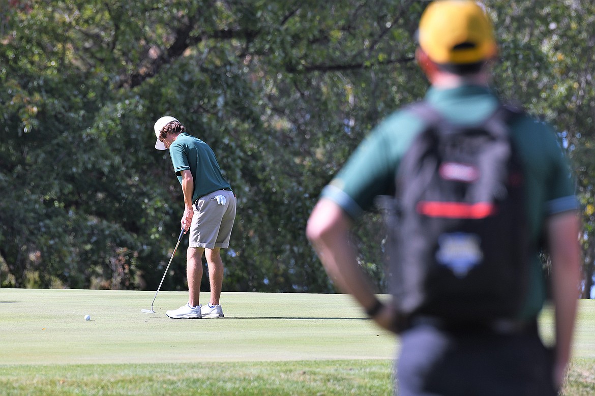 Bulldog Head Coach Tait Rocksund looks on as Marcus Kilman putts at the State A golf tournament in Polson. (Jeff Doorn photo)