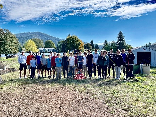 Courtesy photo
Last weekend, the Coeur d’Alene High boys varsity and junior varsity soccer teams gave back to the community by volunteering with a local foster family through Village of Hope, CDA. The boys worked together to take down fences, rake brush into burn piles, carry barbed wire and years of other debris to clean up the property. 
Team manager, Erin Wyatt said they took their cue from seeing the Viking girls soccer team volunteer the previous weekend. “It gives the boys a different perspective of everyday life when they see it through the lens of someone else,” she said. “I’ve never seen a nicer group of young men give up their own time to help someone else. They made the work fun, never stopped laughing as they used old saws they found on the property to cut down fence posts and took turns with sledgehammers to see who could knock things down the fastest. At one point, they found half of a bowling ball and it quickly turned into a scavenger hunt to find the other half. There was something very innocent and endearing in the boys as they found their youthful playfulness in the project.”
Coeur d'Alene varsity coach Braden Ridgewell got down in the dirt with the boys as well, hauling trash and readying burn piles. “I am proud of the boys for coming out as a team to help within the community, this was a very good experience for them,” he said. He said he has a very special group, mentioning that the older boys watch out for the younger boys on and off the field.
Some of the boys moms came out to help as well. “Even as adults, we get wrapped up in our own lives and don’t always see other people in need. It was a proud moment to work side by side with our sons and lead by example,”  Wyatt said. “We have committed as a team to do various volunteer activities throughout the season, it is a tradition that will keep going for the program and will get handed down from year to year.”
From left are coach Braden Ridgwell, Isaac Fritts, Max James, Nate Simon, Keaton Gust, Maddox Le, Nathan Pulsipher, Kason Pintler, Chet Hanna, Nate Wyatt, Liam Martin, Jackson Nickel, Benjamin Crabb, Garrett Scheuermann, Nolan Ludwig, Steven Ball, Evan Lowder, Ashton Fredekind, Landon Cotant, Markus Noble, Logan Haynes and Cooper Prohaska.