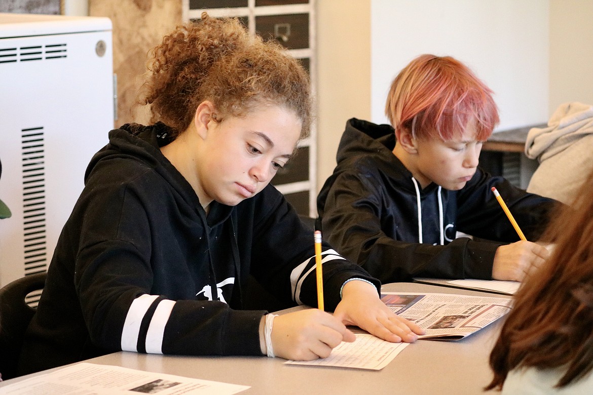 Emma Tevis, front, and Wyatt Dodgson summarize articles from The Coeur d'Alene Press in history class at Lakes Middle School. HANNAH NEFF/Press