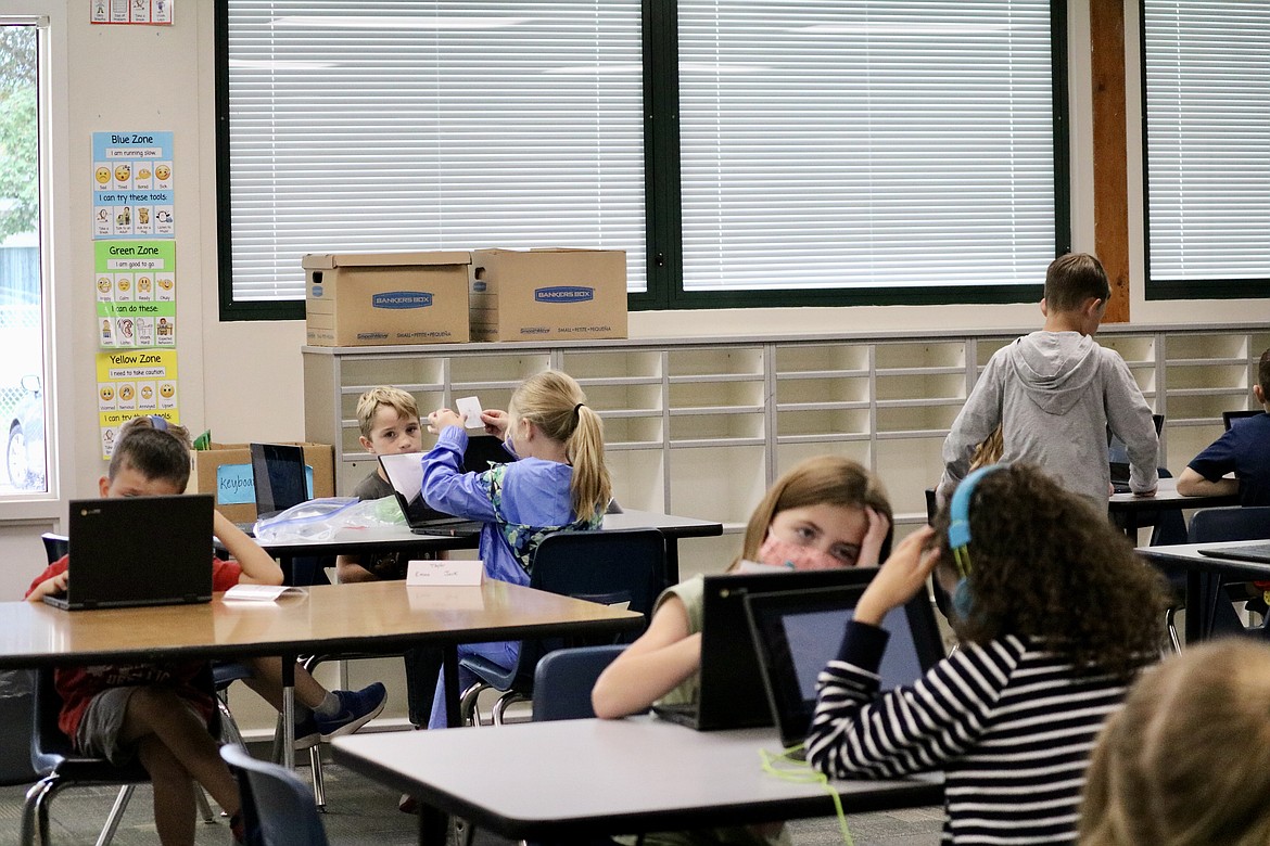 Students at Dalton Elementary School spend a few minutes each week going over the Kid Scoop, a section of The Coeur d'Alene Press geared toward kids. Pictured are second graders in Geri Hagler's tech prep class. HANNAH NEFF/Press