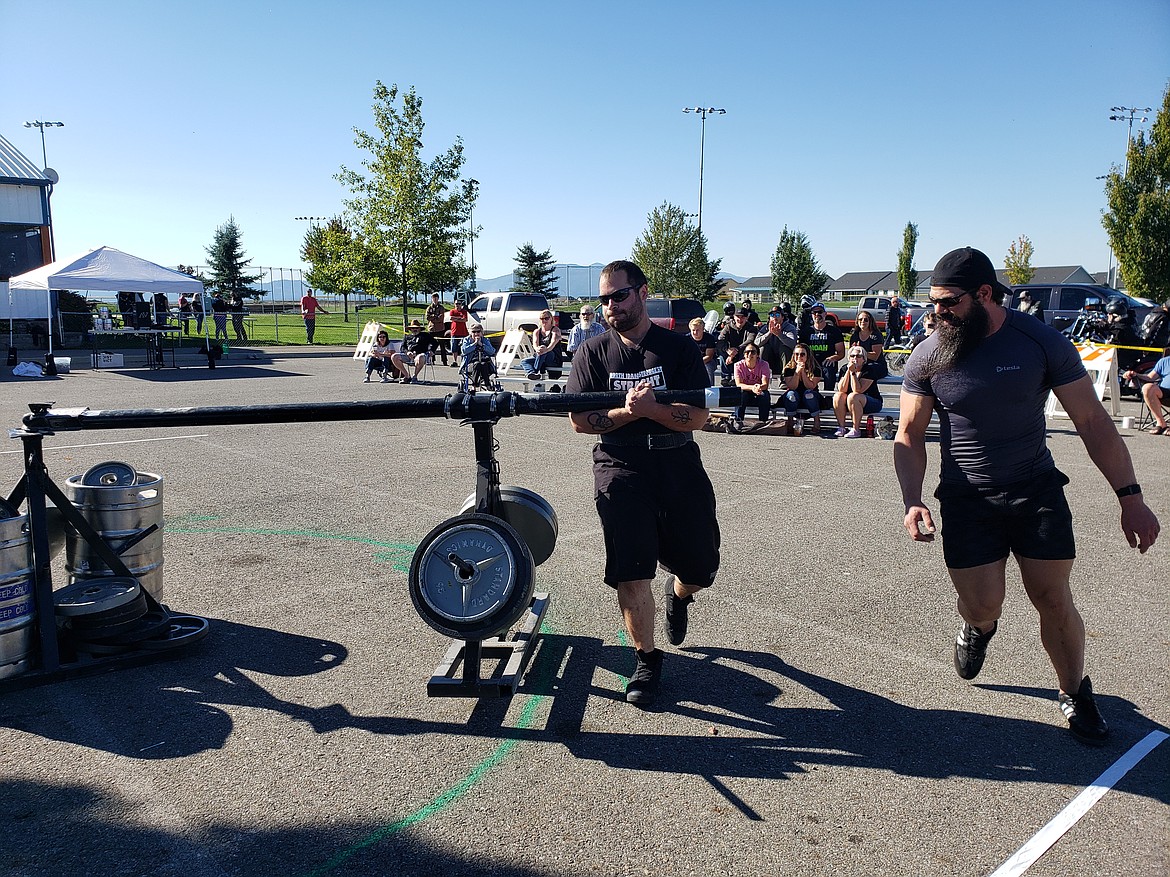Michael Boe pushes through on the Conan's Wheel. Competing against twelve others in five strongman events, Boe took home the Men's Heavyweight Novice title. Matthew Hunter, locally ranked strongman, spots. As a volunteer, judge and sponsor he represents Matthew Hunter Strength and Nutrition.