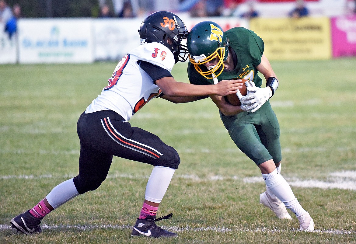 Whitefish sophomore Jesse Burrough tries to push past Chiefs' DaVonne Curley in a game against Ronan on Friday for homecoming. (Whitney England/Whitefish Pilot)