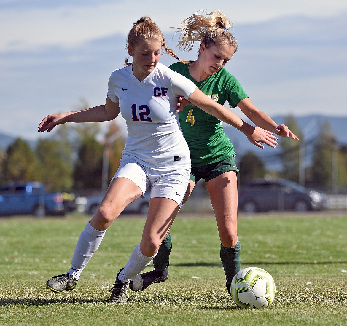 Lady Bulldog Sophie Olson battles with Wildkat Josie Harris during a game in Whitefish on Saturday. (Whitney England/Whitefish Pilot)