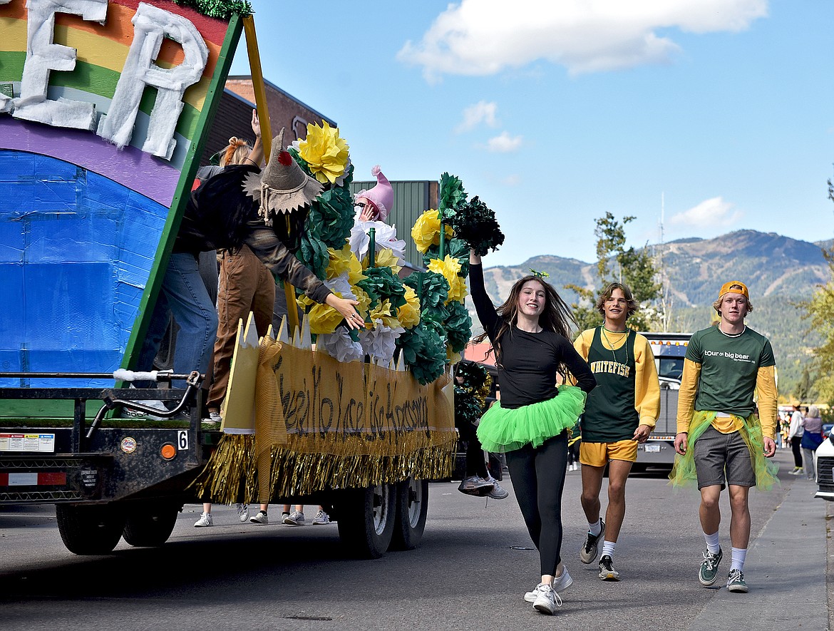 Whitefish students walk alongside the cheerleading float during the Whitefish High School Homecoming parade Friday afternoon. (Whitney England/Whitefish Pilot)