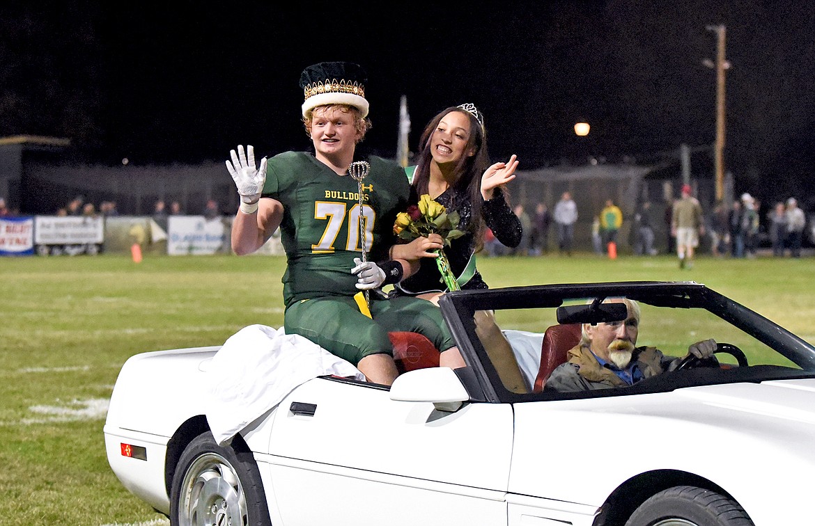 Whitefish High School Homecoming King Barrett Scott and Queen Emma Trieweiler ride off the football field in a convertible after being crowned Friday night. (Whitney England/Whitefish Pilot)