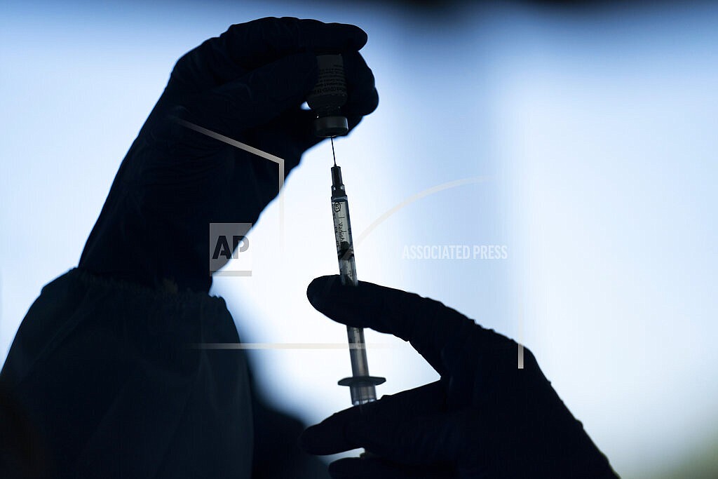 In this Jan. 21, 2021, file photo, a medical staff member prepares the Pfizer COVID-19 vaccine at Tudor Ranch in Mecca, Calif. COVID-19 deaths in the U.S. are coming down again, hospitalizations are dropping, and new cases per day are about to dip below 100,000 for the first time in two months — all signs that the summer surge is waning. Not wanting to lose momentum, government leaders and employers are looking at strengthening and expanding vaccine requirements. (AP Photo/Jae C. Hong, File)
