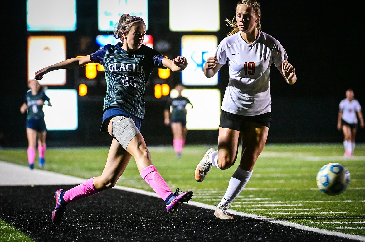 Glacier's Reagan Brisendine (22) passes into the Flathead defensive zone with the Bravettes' Alivia Rinehart (19) defending in the first half at Legends Stadium on Thursday, Oct. 7. (Casey Kreider/Daily Inter Lake)