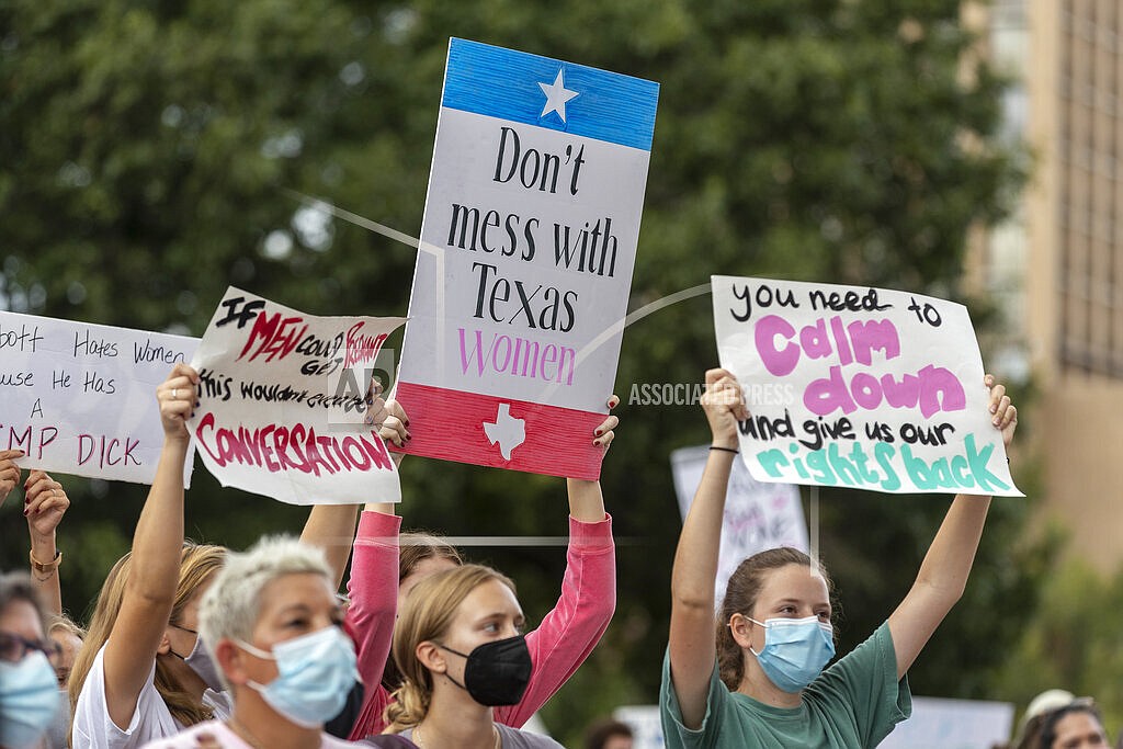 In this Oct. 2, 2021, file photo, people attend the Women's March ATX rally, at the Texas State Capitol in Austin, Texas. A federal judge has ordered Texas to suspend a new law that has banned most abortions in the state since September. The order Wednesday by U.S. District Judge Robert Pitman freezes for now the strict abortion law known as Senate Bill 8. (AP Photo/Stephen Spillman, File)