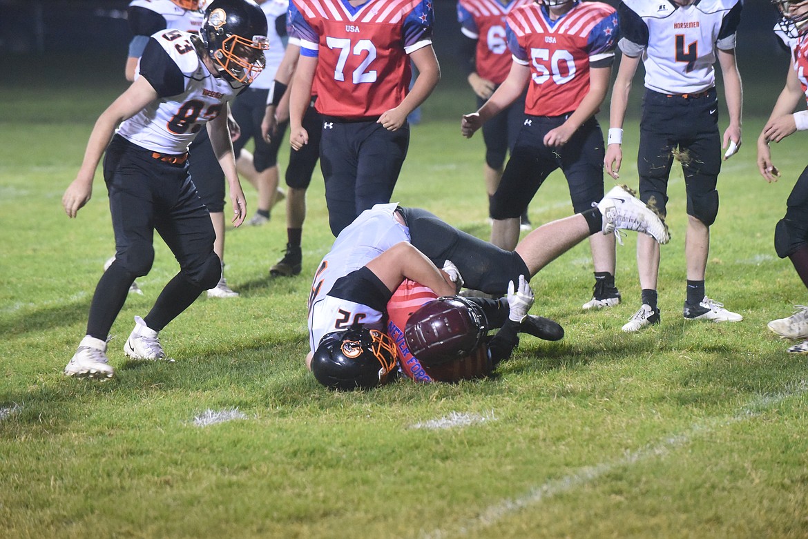 Plains Horseman defender Denny Black wraps up a Troy ball carrier in last week's game. (Scott Shindledecker/Valley Press)