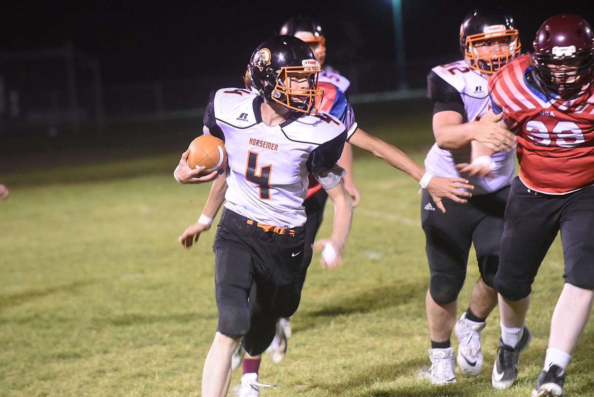 Plains Horseman quarterback Mason Elliott looks for room to run against the Troy Trojans in last week's game. Elliott scored one of two touchdowns for the Horsemen in a 56-14 loss. (Scott Shindledecker/Valley Press)