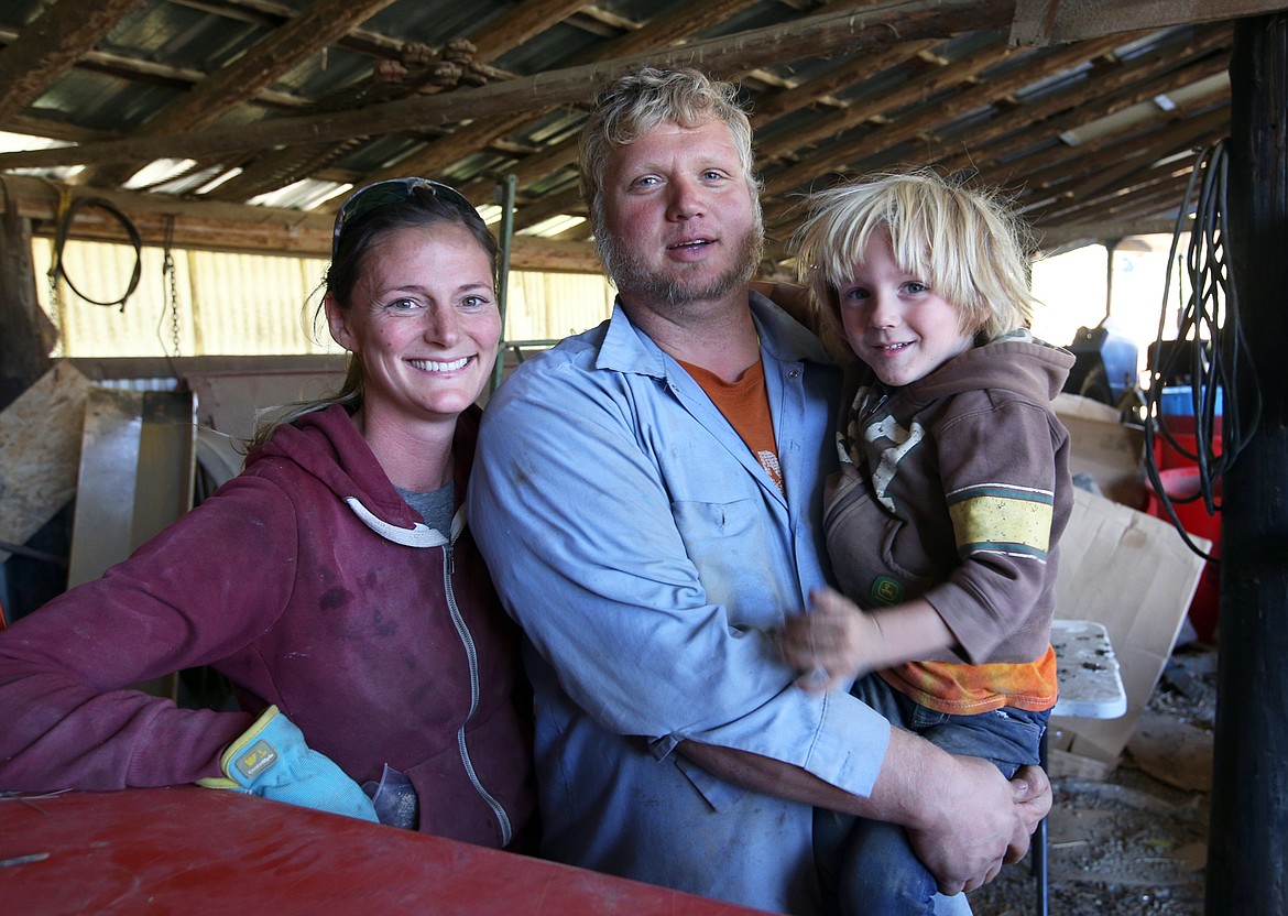 Caleb and Lorissa Thursday, joined by son Wyatt, take a break from a hard day's work at the family farm in Hauser.