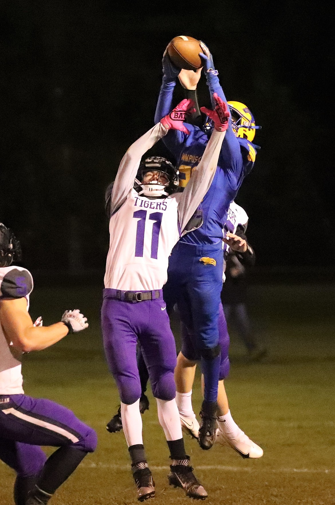 Senior Sam Barnett rises up to make a catch over a pair of Mullan defenders on a trick play during the second quarter of Friday's game.