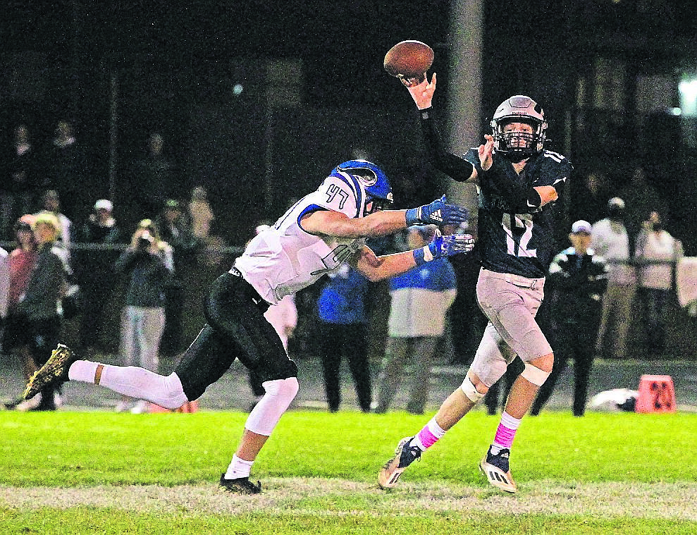 MARK NELKE/Press 
Camden DeGraw (47) of Coeur d'Alene puts pressure on Lake City quarterback Jackson Pettit in the first half Friday night at Lake City.