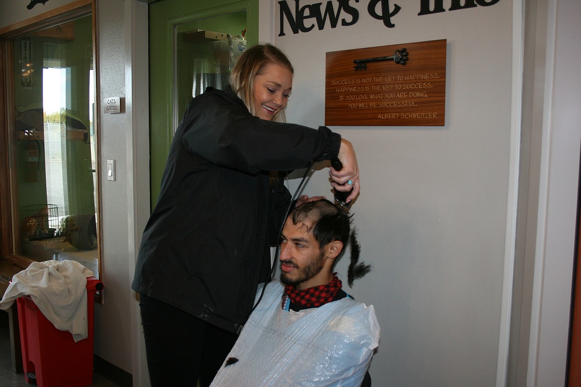 David Leal (right) sacrifices his hair Friday during a fundraiser sponsored by Jordan’s Way for Adams County Pet Rescue. Hannah Hokanson, of Jordan’s Way, did most of the shaving.