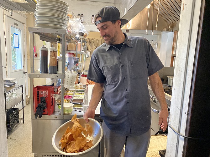 Republic Kitchen & Taphouse chef Lucas Chavez tosses a bowl of the restaurant's house-made chips.