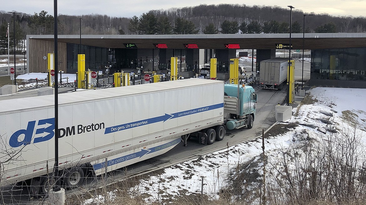 FILE - In this Wednesday, March 18, 2020 file photo, truck traffic from Canada waits to cross the border into the United States in Derby Line Vt. (AP Photo/Wilson Ring, File)