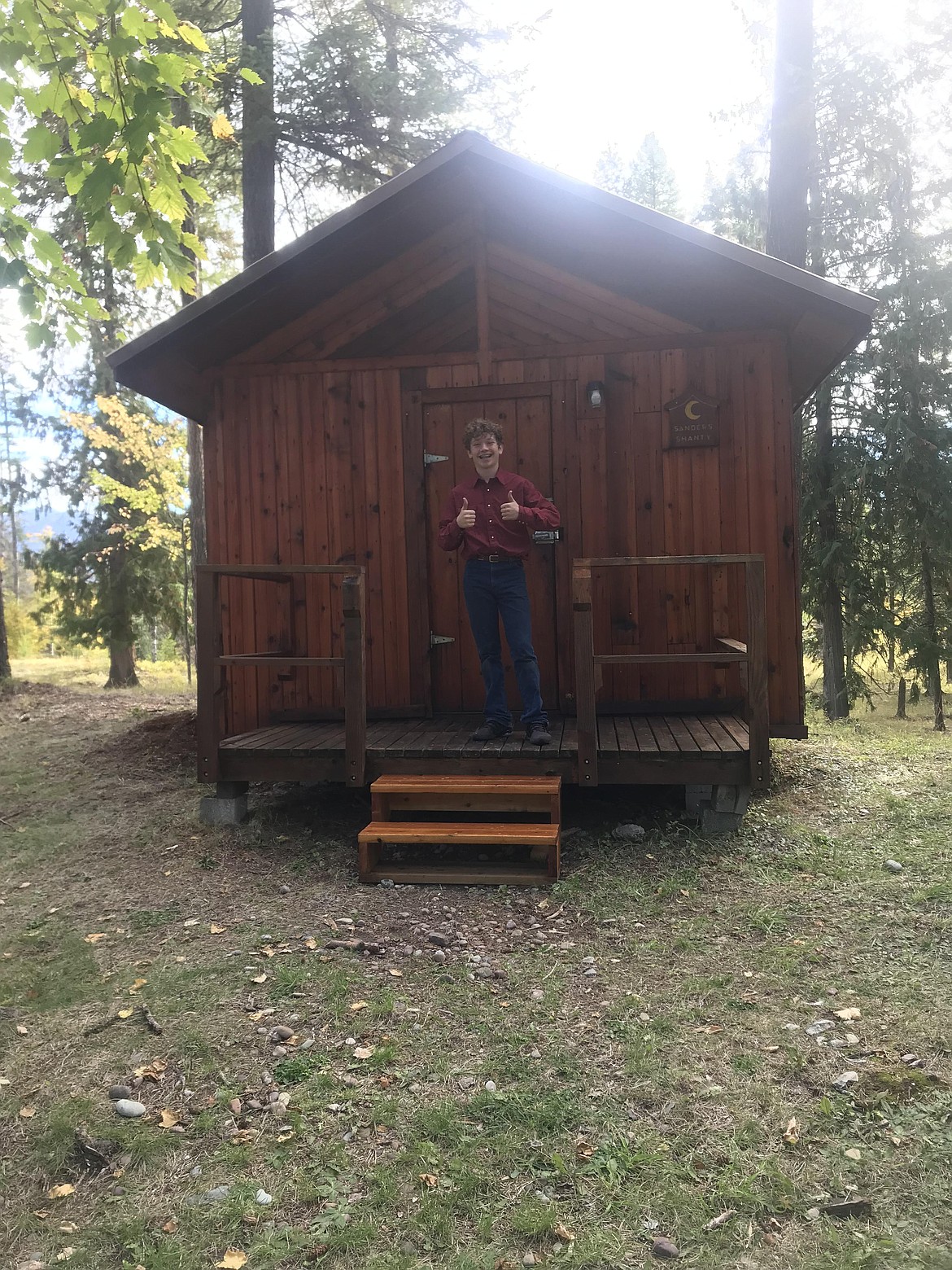 Korbin in front of one of the 4-H cabins