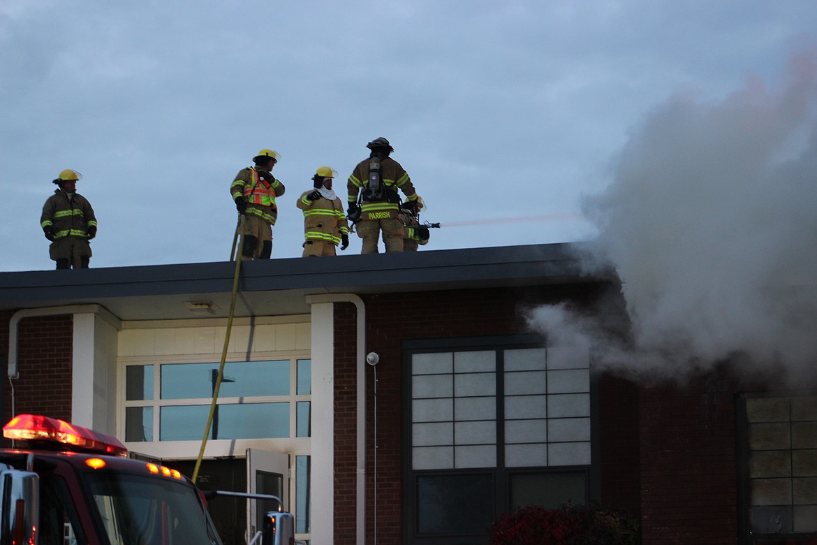 Firefighters fight the fire on the Almira school’s roof.
