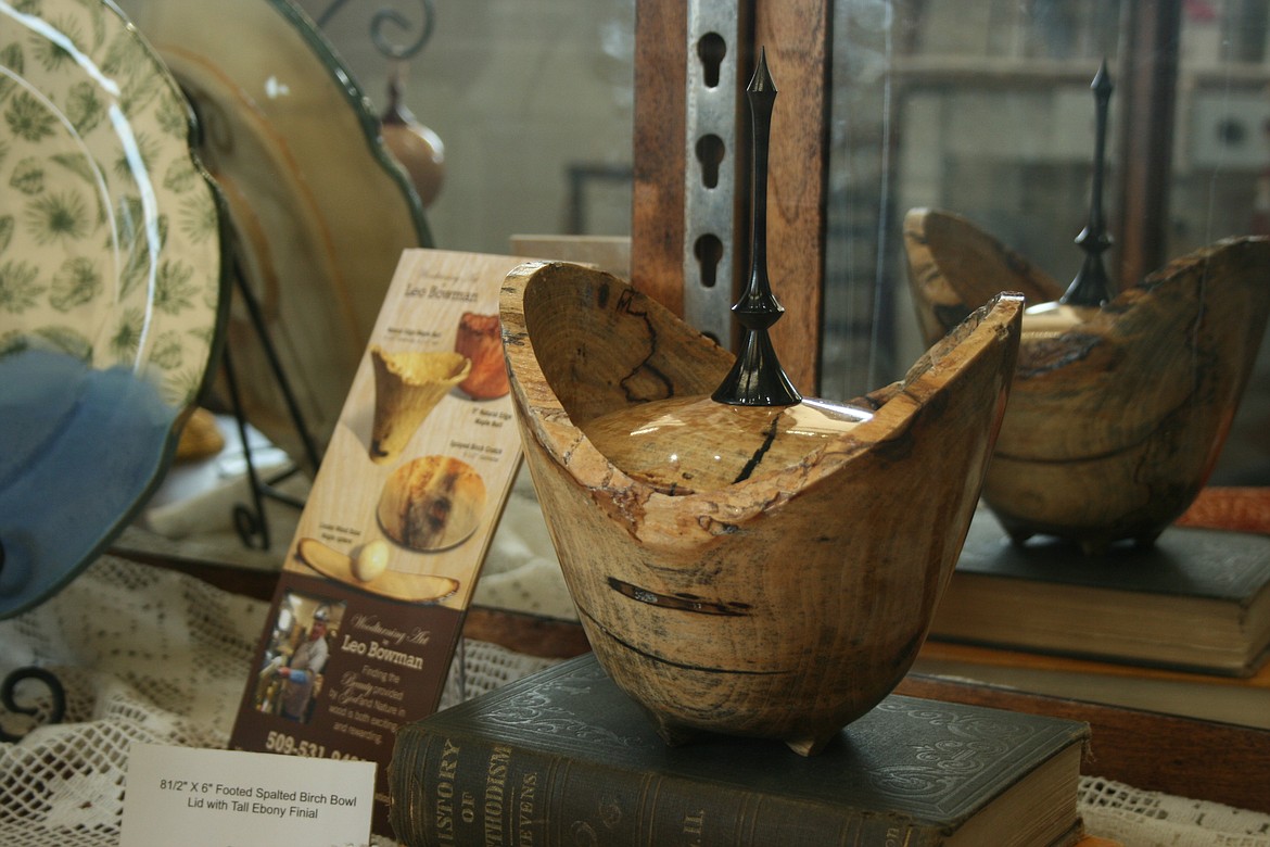 A bowl and sculpture by Tri-Cities artist Leo Bowman is reflected in a display case at the Old Hotel Art Gallery.