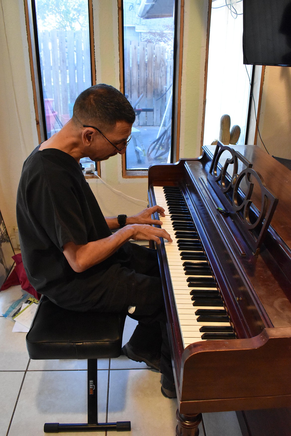 Jesse Alvarado plays the piano in his home, which he uses to practice, write new music and record for his YouTube channel or Facebook page.