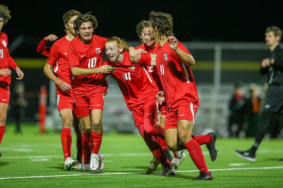 Teammates mob Canyon Nash after he scores the opening goal of Thursday's 4A Region 1 title game.