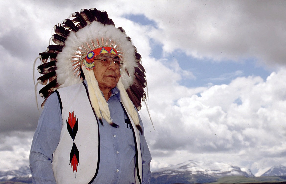 Earl Old Person, chief of the Blackfeet Nation in Browning, Mt., wears a ceremonial headdress at his home overlooking the Rocky Mountains near Glacier National Park, Mont., on June 9, 1998. Old Person had been on the tribal council on and off since the 1950s and was named chief in 1978. Old Person died Wednesday, Oct. 13, 2021, in Browning, after a long battle with cancer, the tribe said. He was 92. (Stuart S. White/The Great Falls Tribune via AP, File)