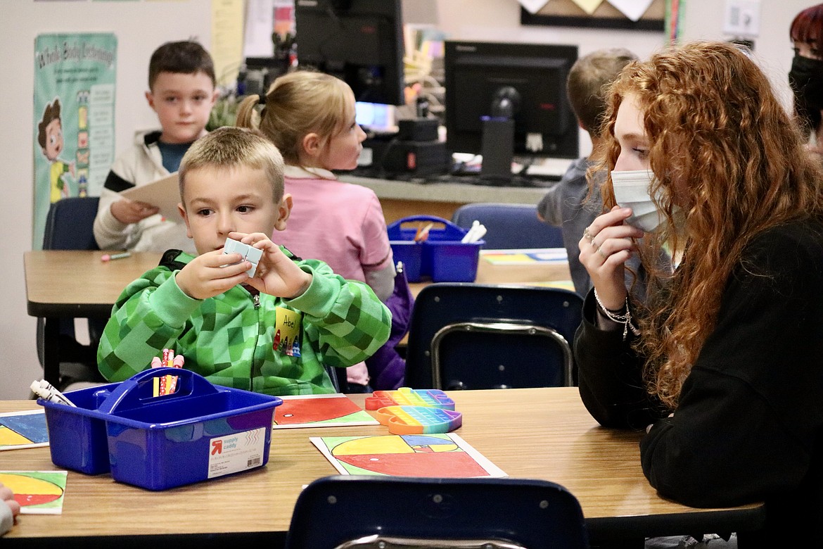 Coeur d'Alene High School junior Lynsey Overturf works with second grader Abel on Wednesday during STEAM club, a new afterschool program at Borah Elementary School that teaches math and science through art lessons and projects. HANNAH NEFF/Press