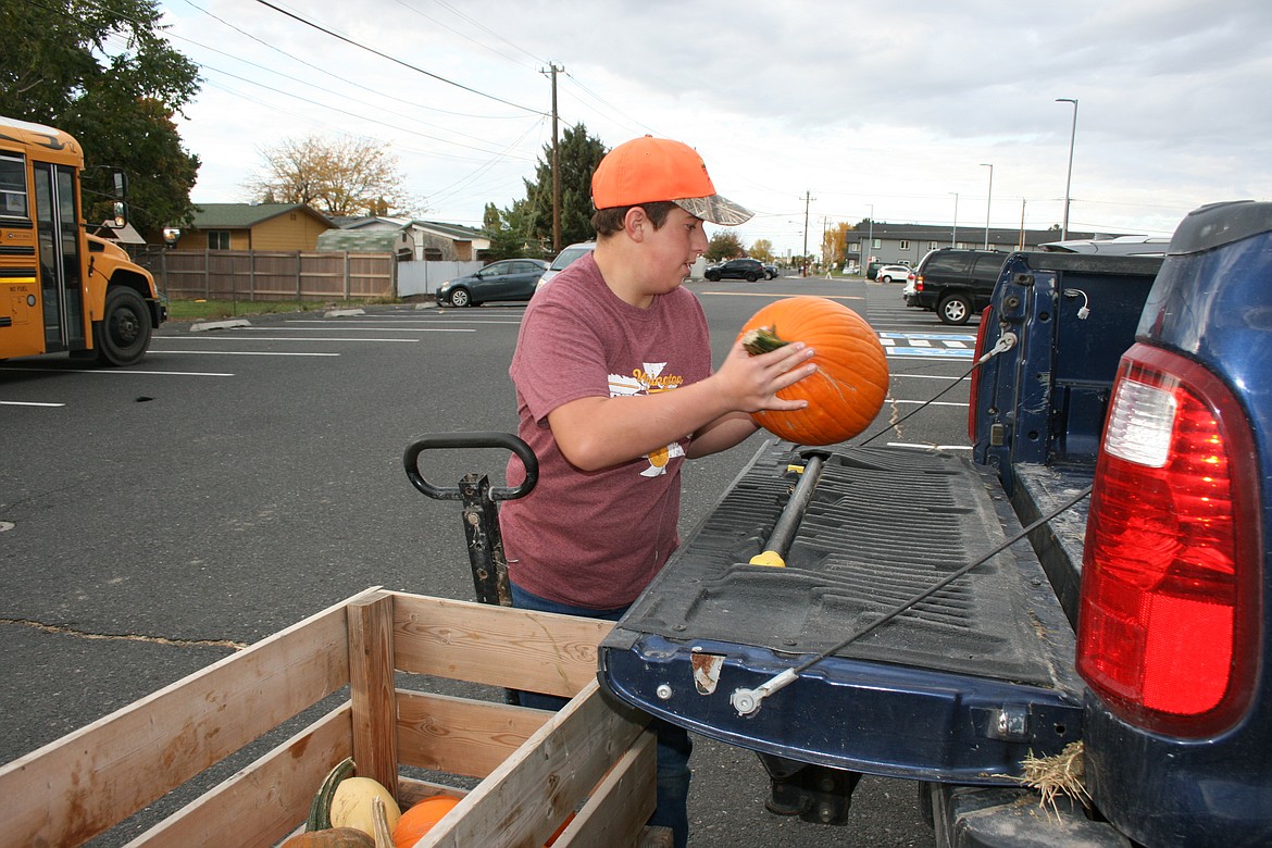 Moses Lake High School FFA member Ethan Wade loads pumpkins for a customer Wednesday.