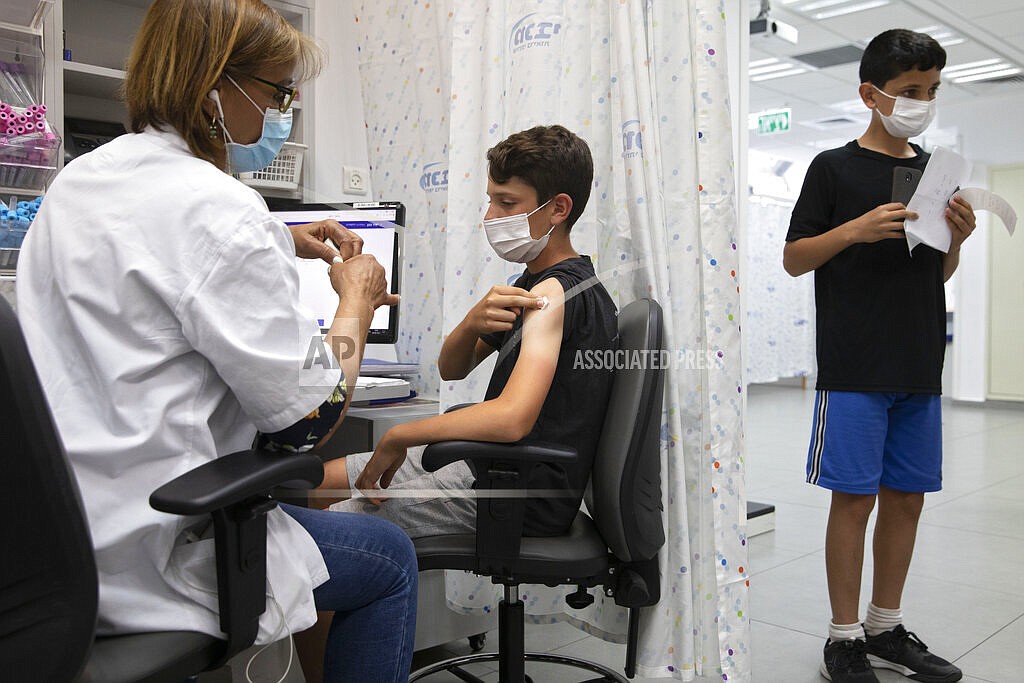 In this June 6, 2021 file photo, a youth receives a Pfizer-BioNTech COVID-19 vaccine in the central Israeli city of Rishon LeZion. The pharmaceuticals Pfizer and BioNTech say they have requested that their coronavirus vaccine be licensed for children aged 5 to 11 across the European Union. If authorized, it would be the first opportunity for younger children in Europe to be get immunized against COVID-19. (AP Photo/Sebastian Scheiner)