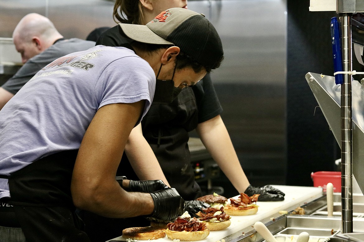 Yamil Maldonado dresses up burgers on the prep line at the new Killer Burger in the Prairie Shopping Center in Hayden, opening today at 11 a.m. HANNAH NEFF/Press