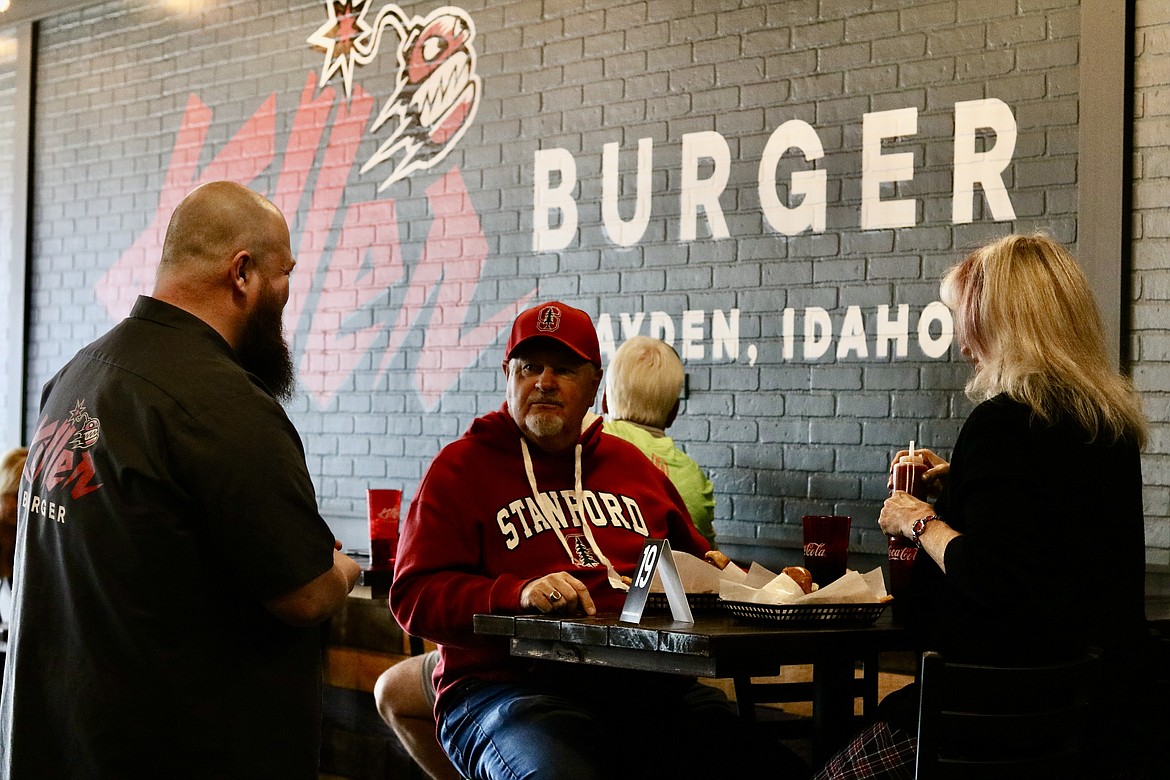 Chad Rouse serves Dan and Connie Brandel of Hayden at the soft opening of new Killer Burger in Hayden, where all burgers are served with bacon, fries and rock 'n' roll. HANNAH NEFF/Press